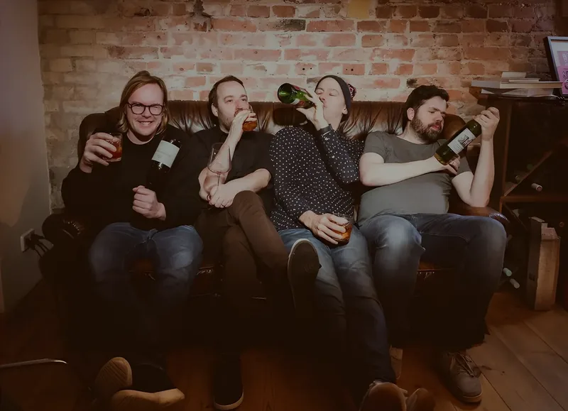 Die vier trinken, einer direkt aus der Flasche.